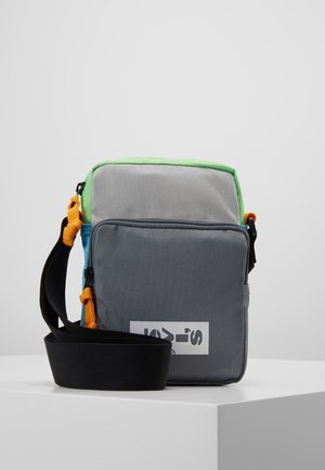 Piccola borsa a tracolla rettangolare in tessuto grigio, verde e blu con accenti arancioni e una larga tracolla nera regolabile.