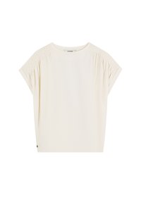 Top de manga corta color crema con detalles fruncidos en las costuras de los hombros, escote redondo y un corte relajado. Tela suave y ligera.