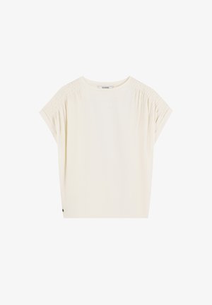 Crèmekleurig T-shirt met korte mouwen met geraffineerde details bij de schoudernaad, ronde halslijn en een ontspannen pasvorm. Zacht, lichtgewicht stof.