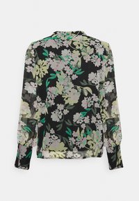 Blouse noire transparente avec un motif floral en nuances de lavande, vert et blanc. Manches ballon avec poignets. Tissu léger.