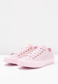 Sneakers in suede rosa chiaro con un design a scarpa bassa, lacci piatti, occhielli in oro rosa e una suola in gomma texture.