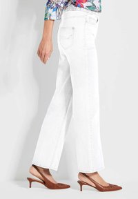 Witte, wijde jeans met een hoge taille en denim stof, gecombineerd met bruine, met hakken slingback schoenen met subtiele plooien bij de tenen.