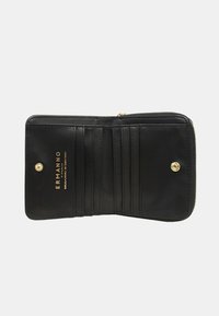 Portafoglio in pelle nera con chiusura a zip, dotato di scomparti per carte e logo dorato del marchio. Texture liscia e design semplice.