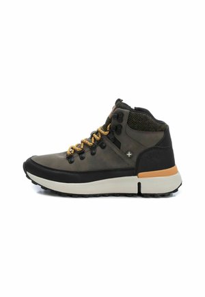 Botas de senderismo en material gris oscuro y negro, con cordones amarillos, acentos texturizados y una suela resistente. Tobillo reforzado para mayor soporte.