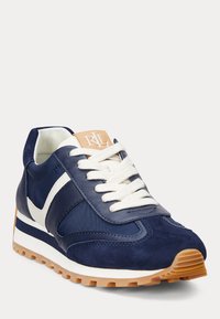 Donkerblauwe sneakers van suède en stof, met witte details, crèmekleurige veters en een rubberen zool in gomkleur met een gestructureerd profiel.