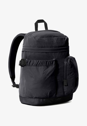 Sac à dos noir avec un dessus arrondi, des bretelles rembourrées ajustables, plusieurs poches zippées et un tissu texturé pour la durabilité.