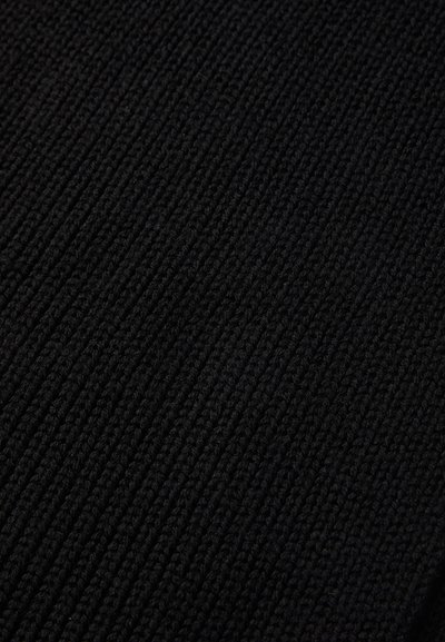 Close-up of black knitted fabric showing a ribbed texture with vertical stitch patterns.
