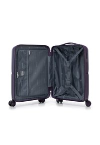 Purple hardshell suitcase, opened, features a striped gray interior, zippered mesh pocket, cross straps, and smooth-rolling wheels.