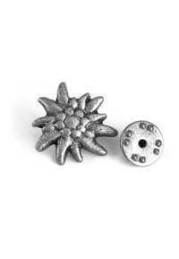 Silberner Metallanstecker in Form einer Sternblume, mit strukturierten Blütenblättern und einem runden Rücken mit einem einzelnen Loch zur Befestigung.