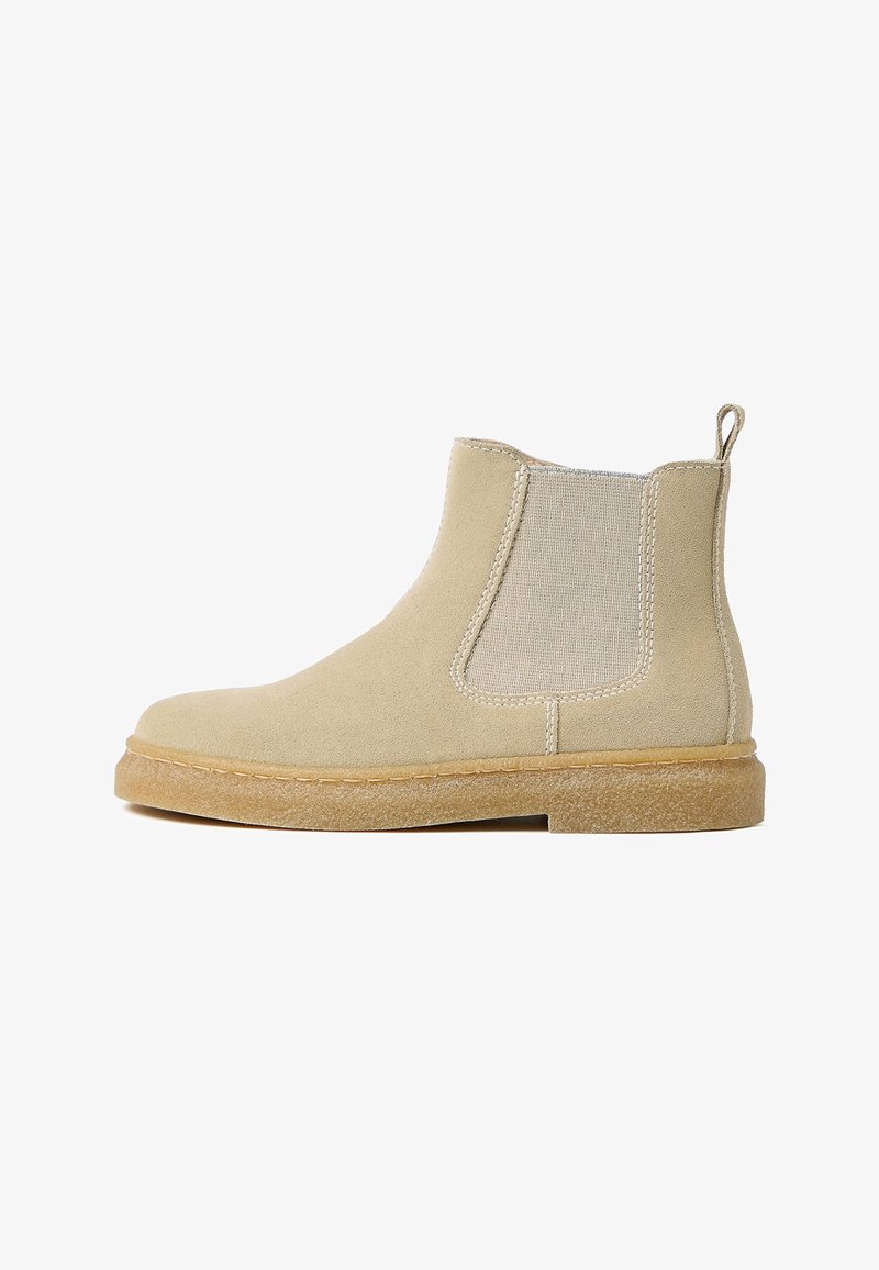 Stivaletti alla caviglia in suede beige con pannelli laterali elastici, un design con cuciture e una suola in gomma testurizzata. Punta chiusa con una linguetta.