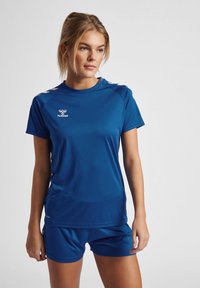 Blå atletisk skjorte og shorts sæt lavet af glat, letvægtsstof. Har logo på skjorten og sporty skulderdetaljer.