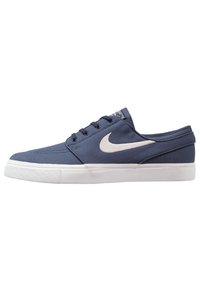 Sneaker basso blu navy con suola bianca e logo Nike swoosh bianco, dotato di chiusura con lacci e upper in tessuto texturizzato.