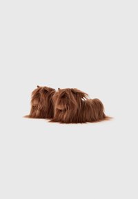 Bruna, fluffiga tofflor som påminner om små djur, med en lång, hårig textur, rund form och subtila ögon detaljer i ett mjukt, plyschmaterial.