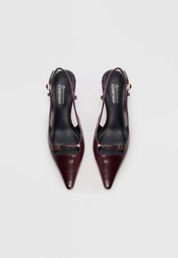 Burgundy, vegaanista nahkaa olevat slingback-korkokengät, joissa on terävät varpaat, ohuet nilkkahihnat ja pieni metallinen solki yksityiskohtana.