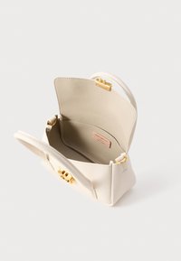 Witte leren handtas met gouden hardware. Open bovenkant onthult een ruime binnenkant met een gladde textuur en een logo label. Glad, gestructureerd ontwerp.