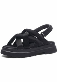 Zwarte sandalen met gekruiste stoffen bandjes, een dikke rubberen zool en een gewatteerde enkelband voor comfort. Geprofileerde zool voor grip.