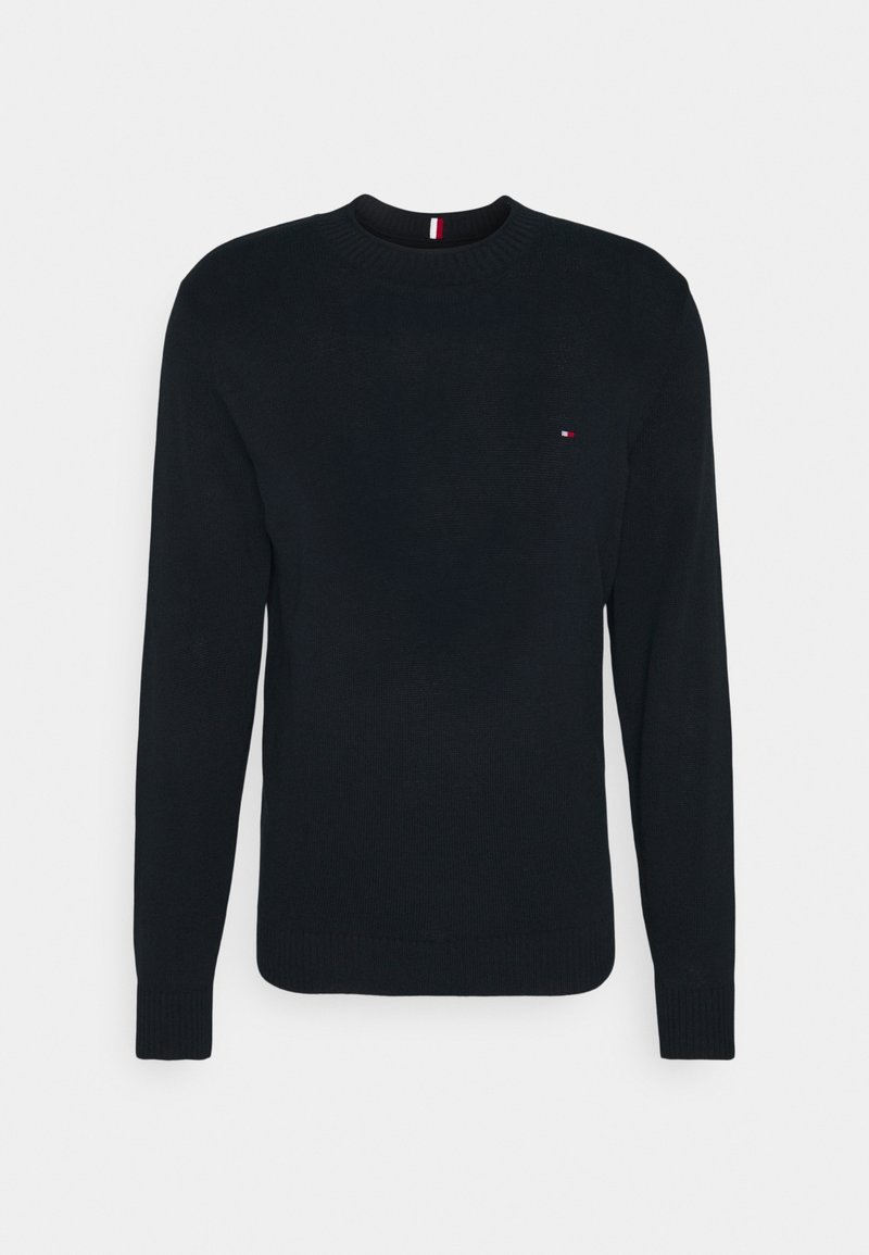 Pull noir à manches longues avec col rond, poignets et bas côtelés, présentant un petit logo rouge, blanc et bleu sur la poitrine gauche.