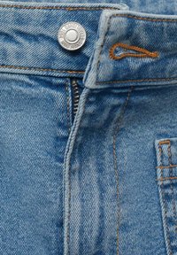 Blue denim jeans with a visible metal button, orange stitching, and a zipper. The texture is smooth with a slightly faded finish.