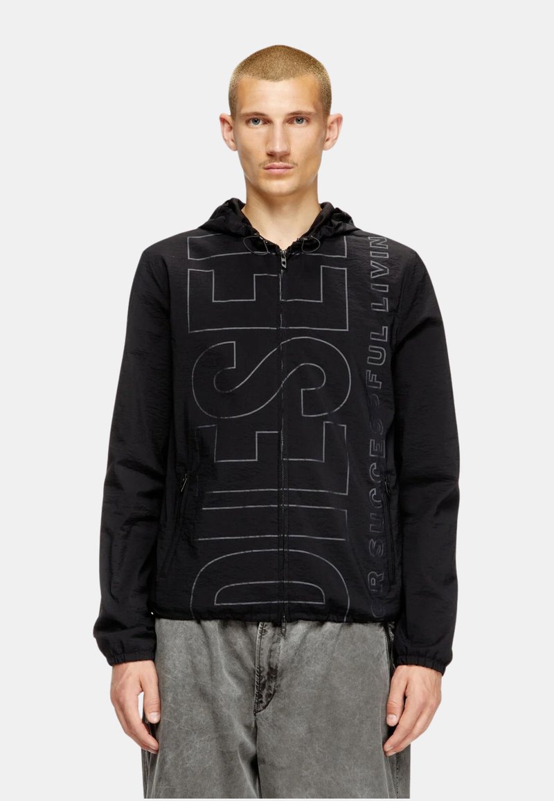 Veste zippée noire avec capuche, arborant un grand texte "DIESEL" en noir légèrement plus clair. Fabriquée en matériau léger et texturé.