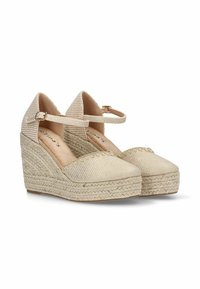 Zapatos de cuña de esparto beige con un empeine de tela texturizada, correa de tobillo ajustable y una entresuela de yute trenzado. Diseño de punta redonda.