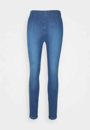 Jean skinny bleu taille haute avec un devant lisse, sans poches ni boutons visibles, présenté sur un fond blanc.