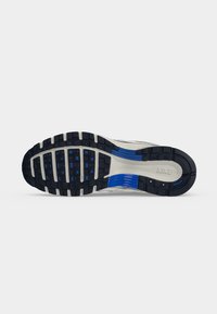 Σόλα παπουτσιού Nike για τρέξιμο με μαύρα και μπλε λαστιχένια πέλματα και λευκή μεσαία περιοχή που δείχνει το λογότυπο Nike.