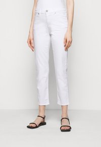 Bílé zkrácené džíny s rovného střihu, s zipovým zapínáním, knoflíkovým uzávěrem a předními kapsami. Vypadá skvěle s černými plochými sandály na řemínky.