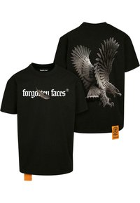 Sort T-shirt med et stort, detaljeret ørnegraphic på ryggen, "glemte ansigtter" tekst på forsiden og et orange label på siden.