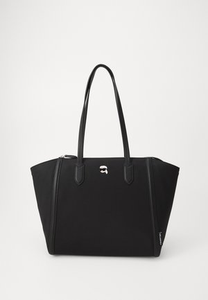 Fekete válltáska tartós szövetből, két füllel, cipzáros záródással és egy kis fehér logóval az elején. Sima textúra.