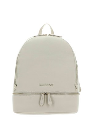 Sac à dos en cuir beige clair avec un dessus arrondi, deux fermetures éclair à l'avant et un logo embossé en bas. Dispose d'une poignée supérieure.