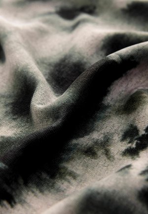 Struktureret stof i nuancer af grå og sort med et subtilt tie-dye mønster. Materialet virker let og falder blødt.