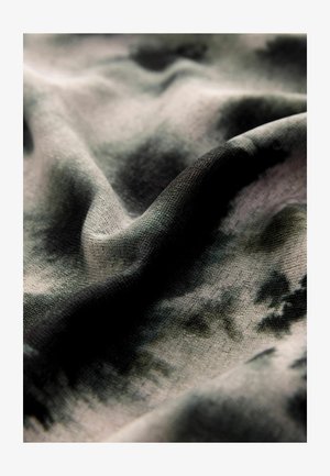 Teksturalna tkanina w odcieniach szarości i czerni, z delikatnym wzorem tie-dye. Materiał wydaje się lekki i miękko układa się.