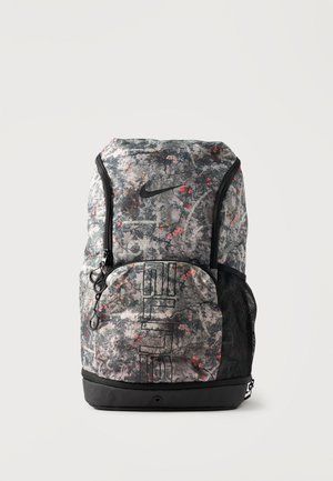 Sivi i crni Nike ruksak s cvjetnim uzorkom, prednji džep s patentnim zatvaračem, mrežasti bočni džep i dvostruki okomiti patentni zatvarači na gornjem dijelu.