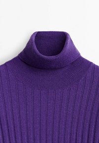 Pull à col roulé côtelé violet avec un col haut, présentant une texture douce et une coupe ajustée. Des lignes verticales parcourent tout le tissu.
