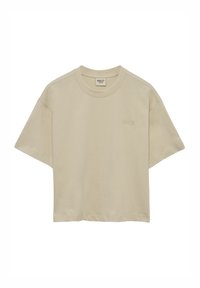 Beige cropped t-shirt van zacht materiaal, met een ronde hals en korte mouwen. Subtiele logo stikdetail aan de voorkant.