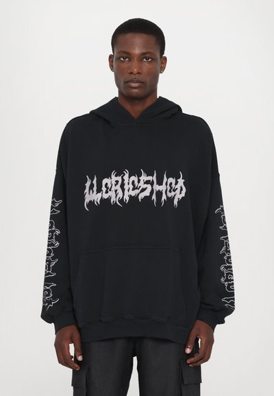 Sudadera negra con gran texto en estilo llama blanca en la parte frontal, con diseños gráficos detallados en ambas mangas. Material de algodón, estilo con capucha.