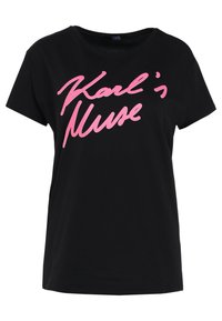 Černé bavlněné tričko s krátkými rukávy, na kterém vyniká stylizovaný růžový nápis "Karl's Muse" na přední straně. Klasický design s kulatým výstřihem.