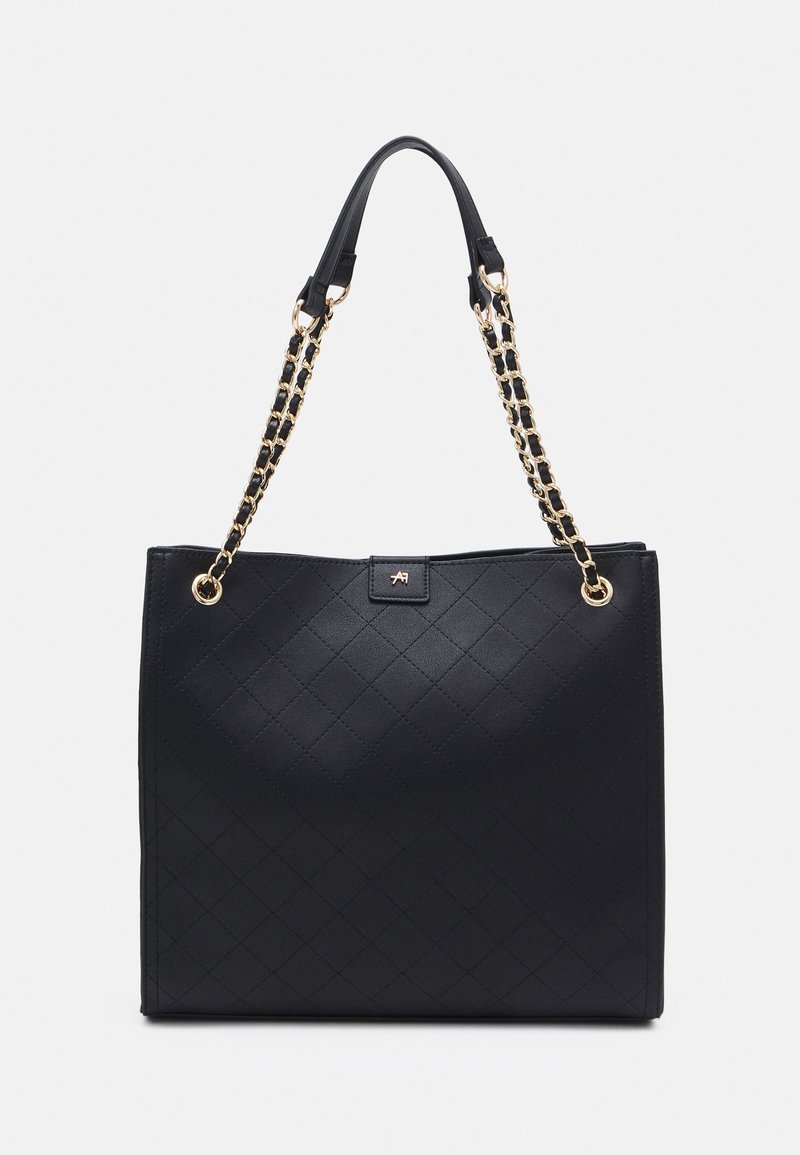 Svart totebag med quiltad mönster, utrustad med axelband av guldfärgade kedjelänkar och en logotypplatta framtill. Material av slätt läder.