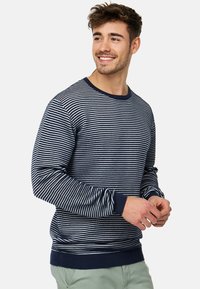 Marineblauw en witte gestreepte trui met ronde hals, geribbelde manchetten en zoom, gemaakt van een zachte stof, met een comfortabele, relaxte pasvorm.