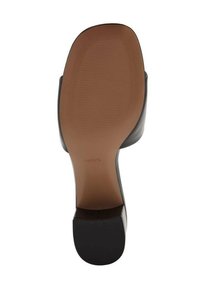 Black heeled shoe sole with smooth brown rubber; features horizontal ridges and a squared toe. Brand name "MNG" embossed on the sole.