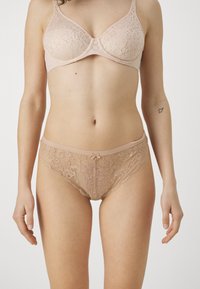 Beiger Spitzen-BH und passender Spitzen-Slip. Strukturiertes Blumenmuster mit einem Satin-Schleifen-Detail auf dem Slip. Weicher, dehnbarer Stoff.