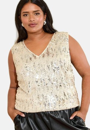 Kerman sequined tank top, jossa on V-aukko, kimaltelevat paljetit, kevyet materiaalit ja sivukiristykset. Yhdistetty mustiin housuihin.