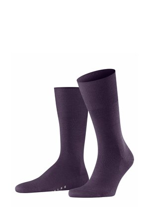 Dunkelviolette Socken mit geripptem Bund und glattem Körper, aufrecht vor einem weißen Hintergrund präsentiert. Die Markenkennung ist im Bereich der Zehen sichtbar.