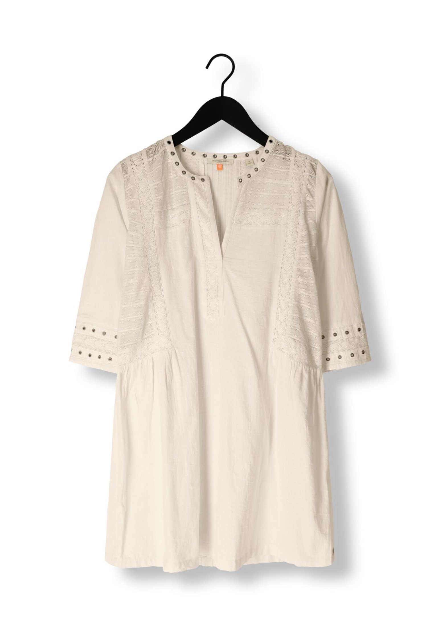 White blouse on a black hanger, featuring short sleeves, decorative stitching, and decorative metal studs around the neckline and sleeves.