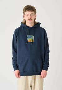 Navy blue hoodie made of cotton with a front pocket. Features a graphic print in the center, drawstrings, and ribbed cuffs.