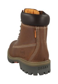 Bota de trabajo de cuero marrón con un cuello acolchado de color marrón oscuro, costuras blancas y una suela de goma gris resistente. Cuenta con una pestaña de acento naranja.