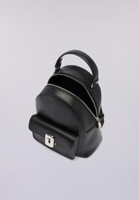 Černý kožený batoh s kulatým tvarem, stříbrným kováním, horní rukojetí a přední kapsou s klopou, která se uzavírá na zacvaknutí.