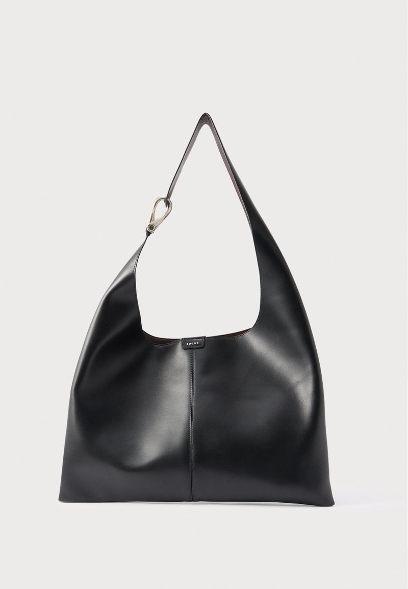 Μαύρη μαλακή δερμάτινη τσάντα ώμου με φαρδιά ταινία και μεταλλικό κούμπωμα σε απλό ανοιχτό φόντο.