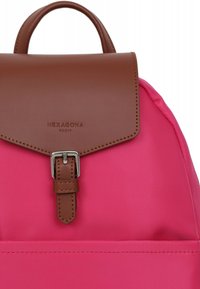 Zaino rosa con un flap in finta pelle marrone, caratterizzato da una fibbia argentata e dettagli cuciti. Il materiale è liscio e resistente.