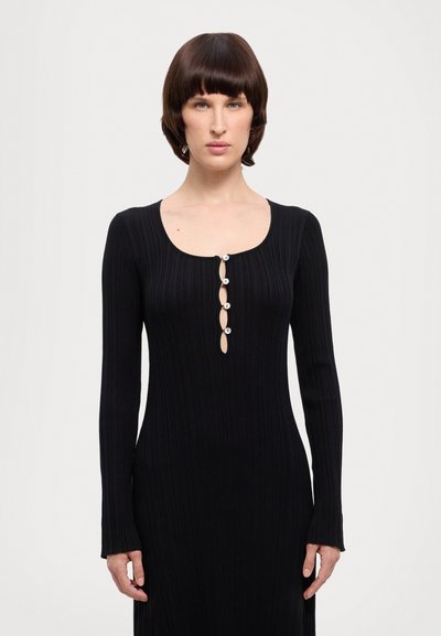 Black ribbed long-sleeve dress with a scoop neckline and five decorative buttons at the front. Fitted silhouette, smooth texture.